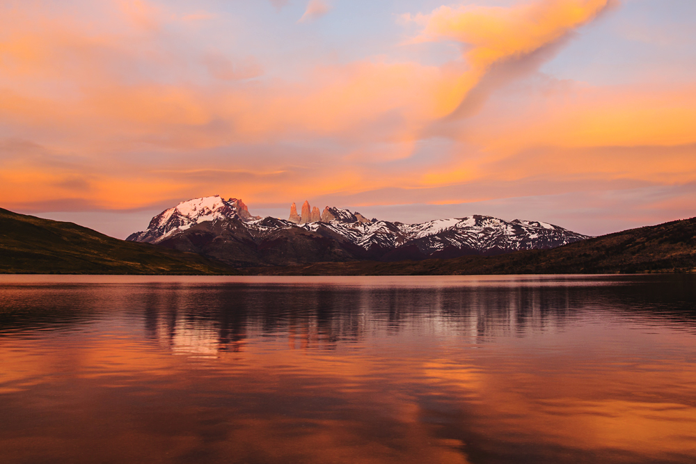 The peaks of Torres del Paine at light of sunrise on a lake, reflection