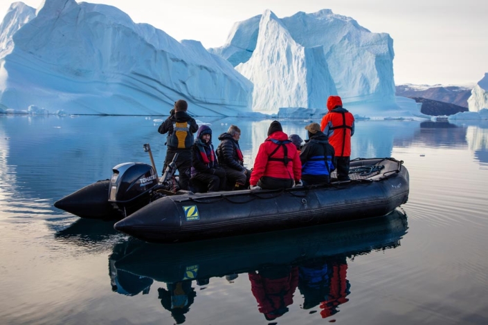 Zodiac with tourists in front of icebergs